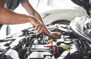 Car mechanich inspects and fixes an engine for a car