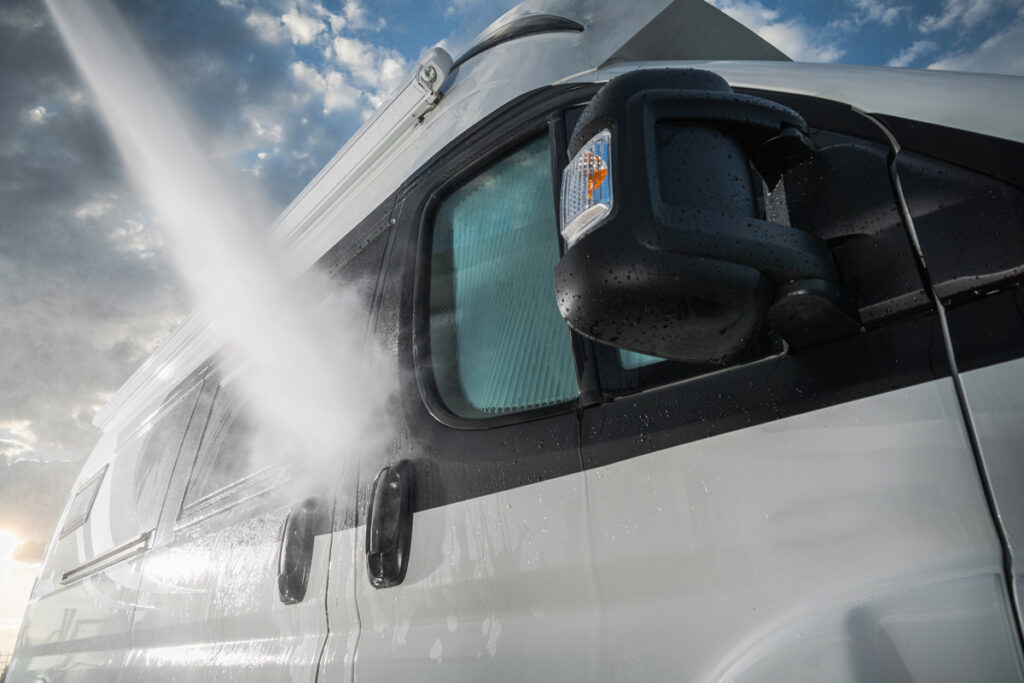 Water spraying on to a white and black RV in El Paso.