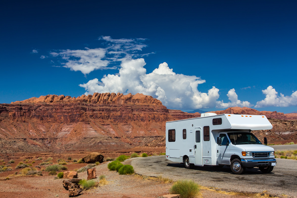 A white RV parked in front of a desert landscape in El Paso.