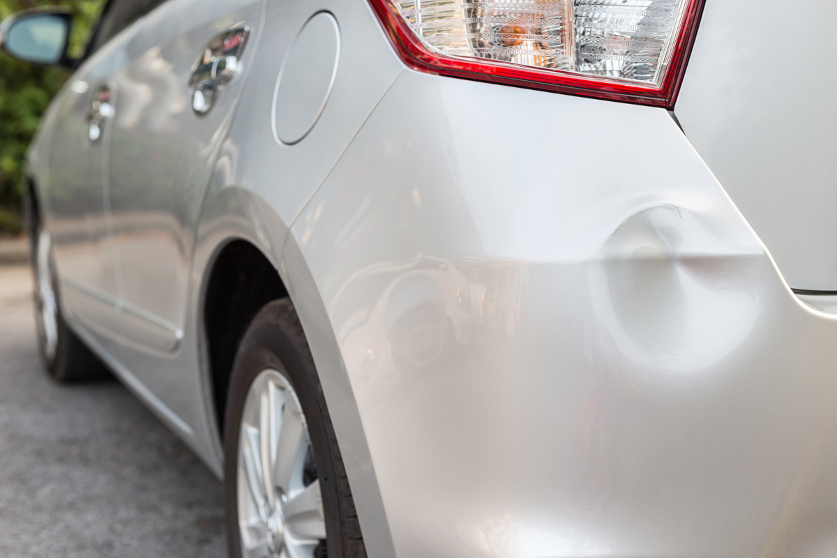 A dent on the back of a white car in El Paso.